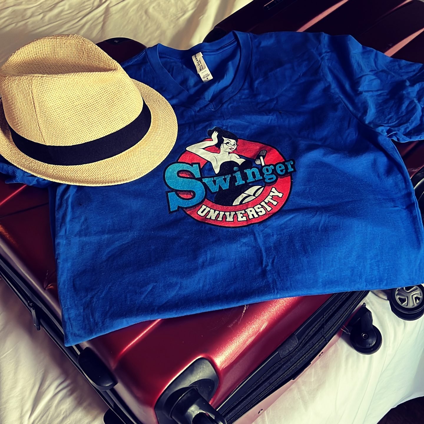 Swinger University Podcast T-shirt on Luggage