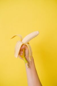 woman's hand holding a half peeled banana