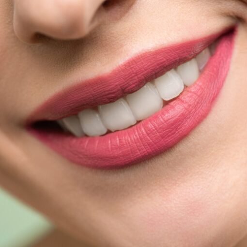 woman smiling with teeth, lips with pink lipstick