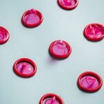 neatly lined up opened pink condoms